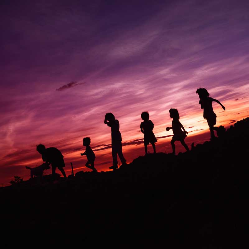 Spielende Kinder vor Sonnenuntergang